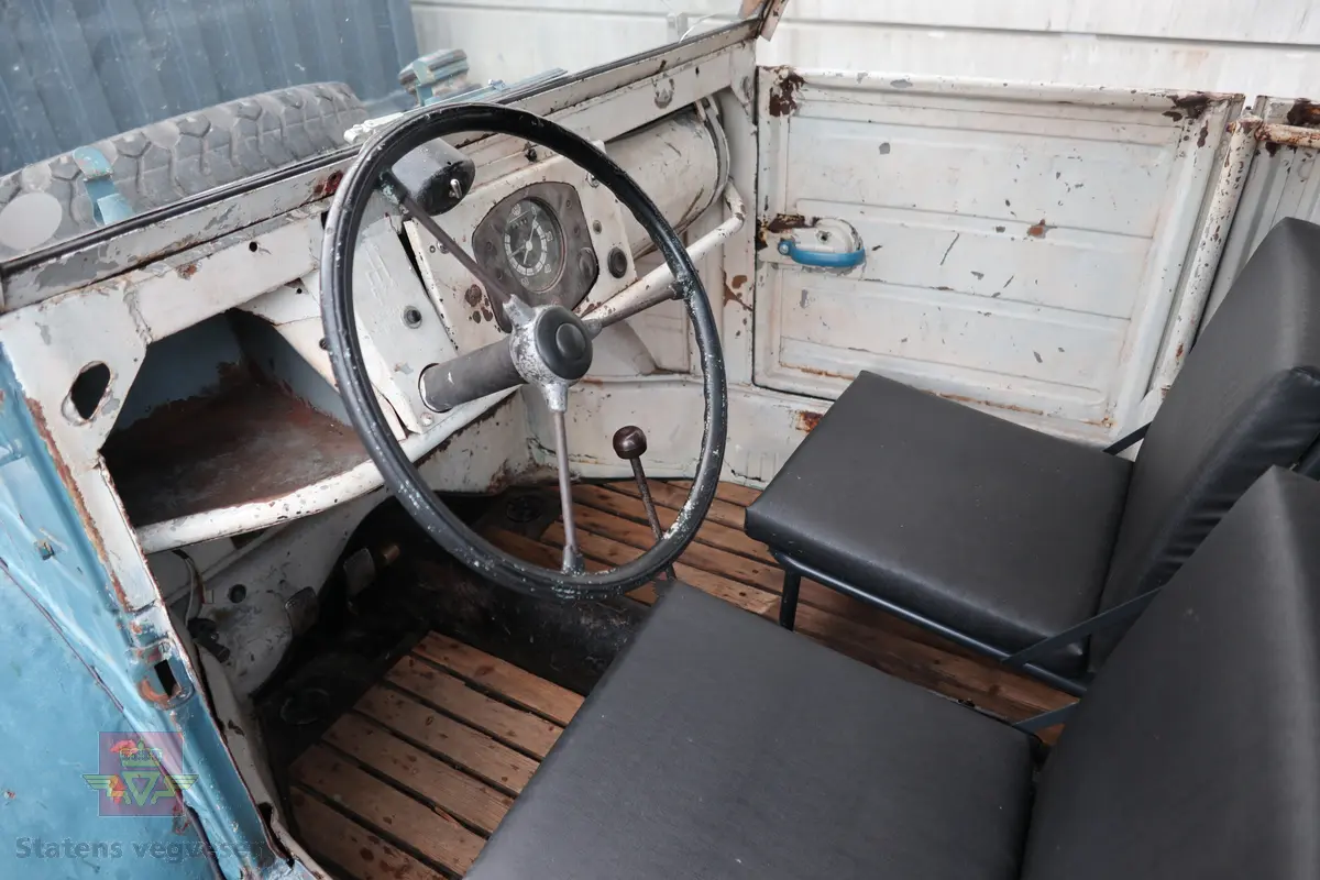 Volkswagen Typ 82 Kübelwagen. Åpen (med kalesje). Blå utvendig og hvit innvendig. Opprinnelig har hele bilen vært sandfarget. Man kan også se rester av grønn farge under det blå. Svart motorrom. Bilen har fire hjul og er toakslet med trekk på bakre. Bensindrevet firesylindret firetakts motor med et sylindervolum på 1192 cm3 og en effekt på 31 hk - 23 kW. Motoren har forgasser, er luftavkjølt, og sitter bak på bilen. 4-trinns manuell girkasse med spak i gulvet. Antall sitteplasser var tre ettersom dette opprinnelig er en radiobil, men nå har bilen sofa bak som tilsier fire sitteplasser totalt. Original dekkdimensjon rundt om skal være 5.00 x 16. Bilen har innvendig gulv av tre, dette er ikke det originale. Frontruta er sprekt. Kilometerstand på instrumentet viser 28084 km.