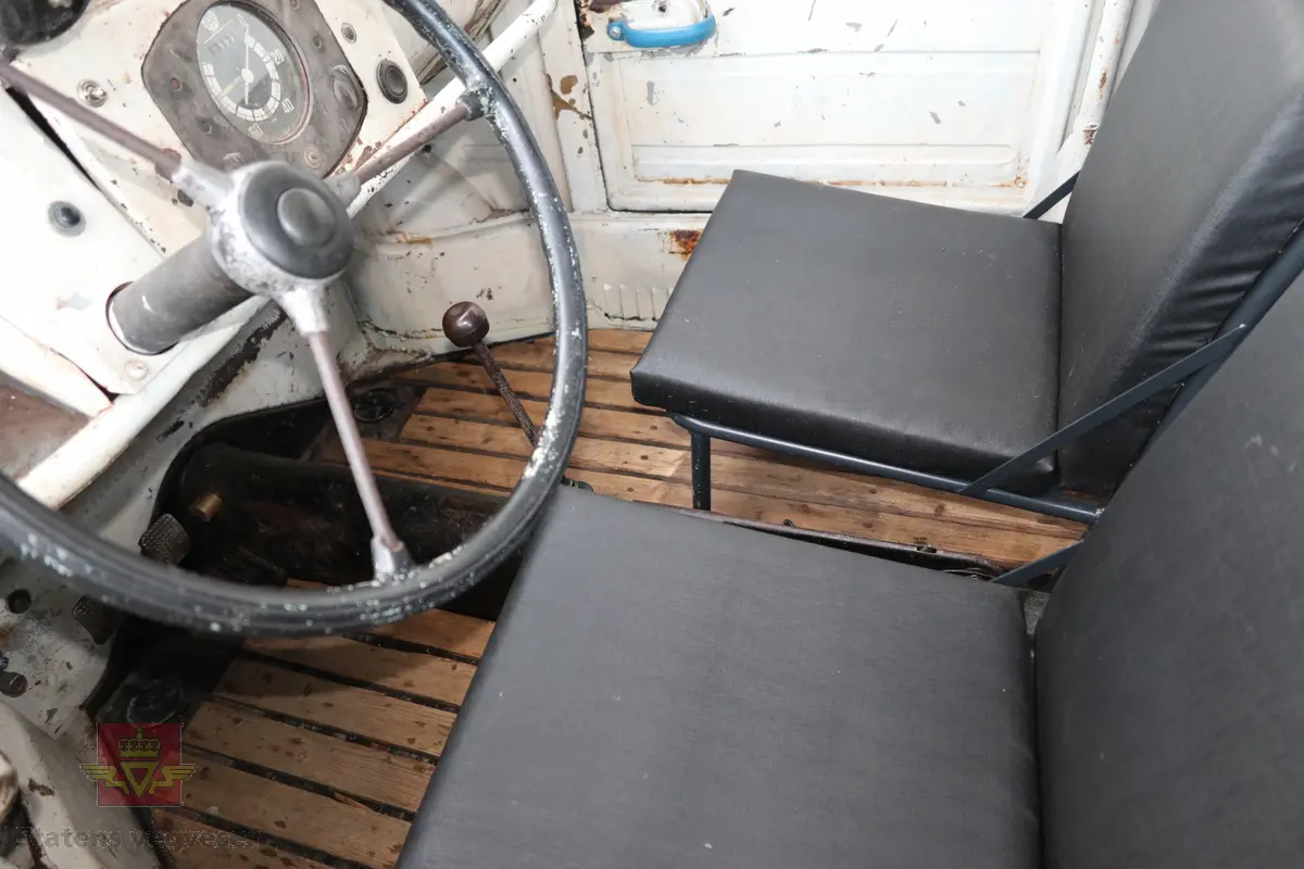 Volkswagen Typ 82 Kübelwagen. Åpen (med kalesje). Blå utvendig og hvit innvendig. Opprinnelig har hele bilen vært sandfarget. Man kan også se rester av grønn farge under det blå. Svart motorrom. Bilen har fire hjul og er toakslet med trekk på bakre. Bensindrevet firesylindret firetakts motor med et sylindervolum på 1192 cm3 og en effekt på 31 hk - 23 kW. Motoren har forgasser, er luftavkjølt, og sitter bak på bilen. 4-trinns manuell girkasse med spak i gulvet. Antall sitteplasser var tre ettersom dette opprinnelig er en radiobil, men nå har bilen sofa bak som tilsier fire sitteplasser totalt. Original dekkdimensjon rundt om skal være 5.00 x 16. Bilen har innvendig gulv av tre, dette er ikke det originale. Frontruta er sprekt. Kilometerstand på instrumentet viser 28084 km.