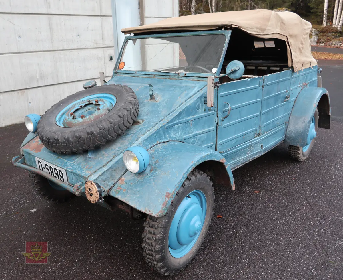 Volkswagen Typ 82 Kübelwagen. Åpen (med kalesje). Blå utvendig og hvit innvendig. Opprinnelig har hele bilen vært sandfarget. Man kan også se rester av grønn farge under det blå. Svart motorrom. Bilen har fire hjul og er toakslet med trekk på bakre. Bensindrevet firesylindret firetakts motor med et sylindervolum på 1192 cm3 og en effekt på 31 hk - 23 kW. Motoren har forgasser, er luftavkjølt, og sitter bak på bilen. 4-trinns manuell girkasse med spak i gulvet. Antall sitteplasser var tre ettersom dette opprinnelig er en radiobil, men nå har bilen sofa bak som tilsier fire sitteplasser totalt. Original dekkdimensjon rundt om skal være 5.00 x 16. Bilen har innvendig gulv av tre, dette er ikke det originale. Frontruta er sprekt. Kilometerstand på instrumentet viser 28084 km.