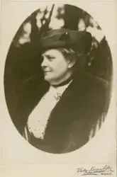 En medelålders kvinna i hatt och pälsbrämad kappa.
I halsgro