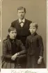 Porträtt av man, kvinna och barn. Text baksida kort: Emmeli, Emil och Mia (otydlig text).