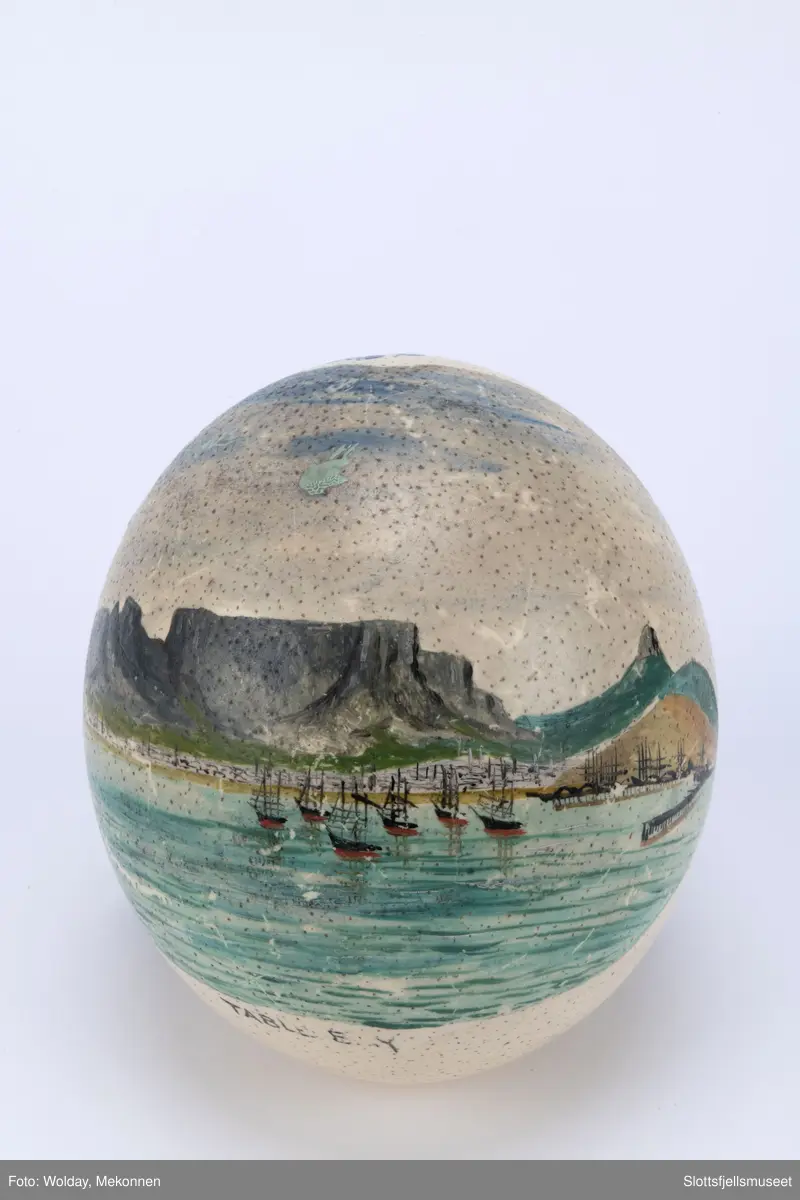Strutseegg dekorert med unionsflagg på den ene side og et bilde fra havnen i Cape Town med Table Mountain på den andre side. Under bildet står det "TABLE E.Y."