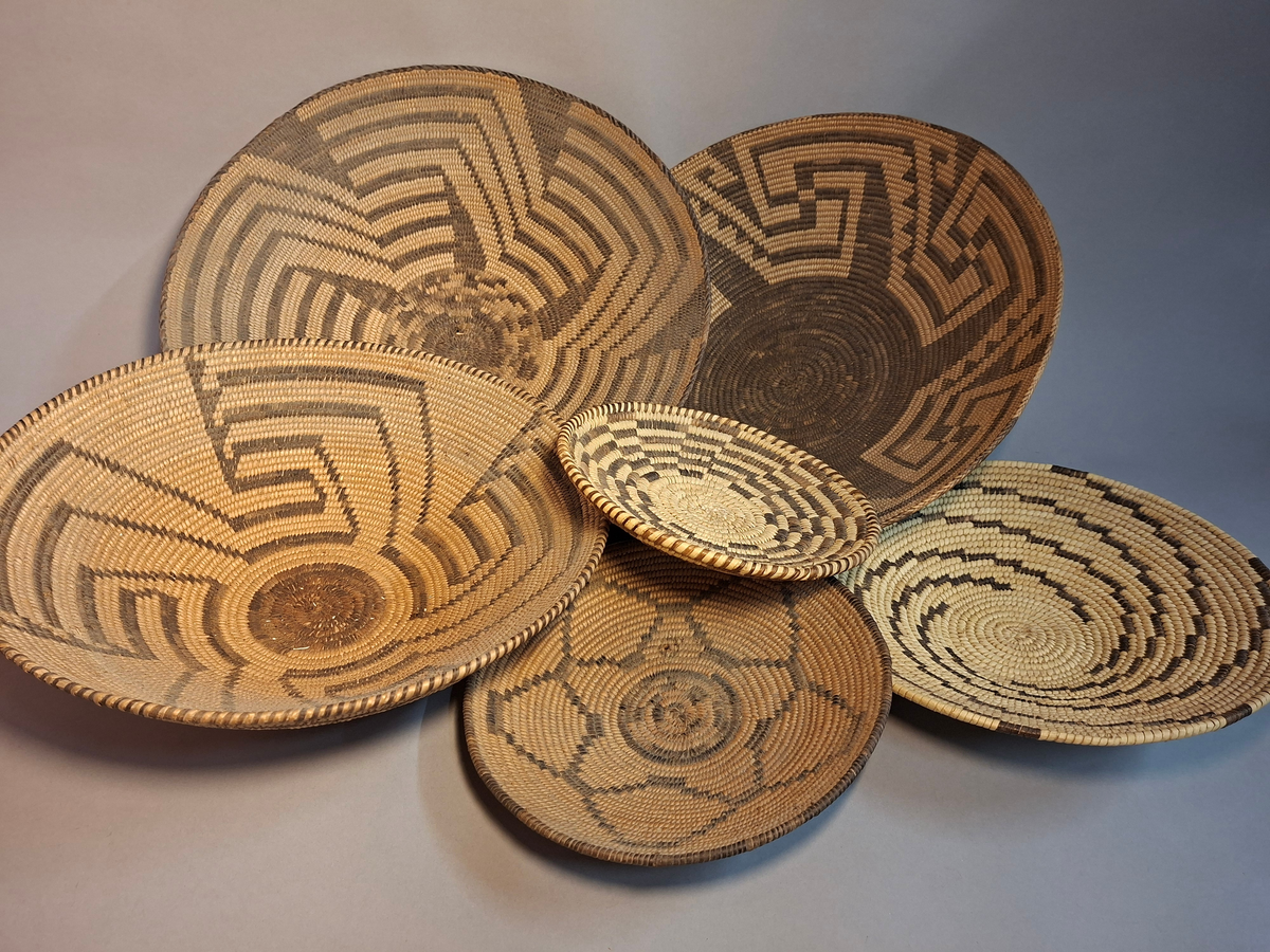 Seks flettede kurver. Flettet i lys og mørk farge, med spiralisert mønster på fire av kurvene, mens de to siste kurvene har stjernemønster og rutemønster.