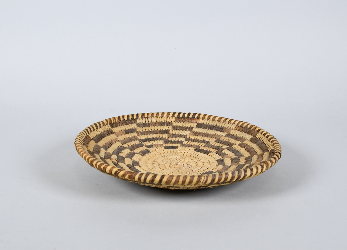 Seks flettede kurver. Flettet i lys og mørk farge, med spiralisert mønster på fire av kurvene, mens de to siste kurvene har stjernemønster og rutemønster.