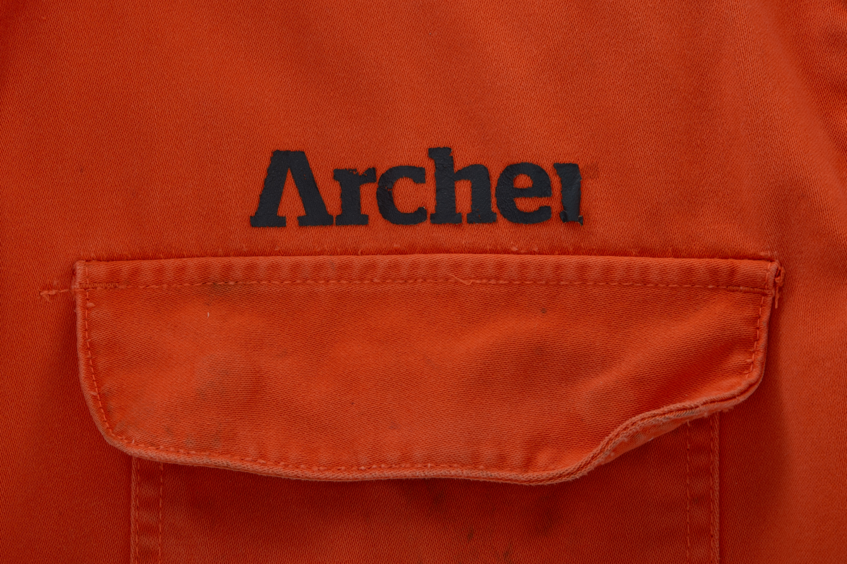 Kjeledress i størrelse 60 med Archer sin logo. Kjeledressen er utstyrt med flere utvendige lommer og reflekser. Innvendig i nakke er det festet en etikett med plattformnavn og QR-kode.