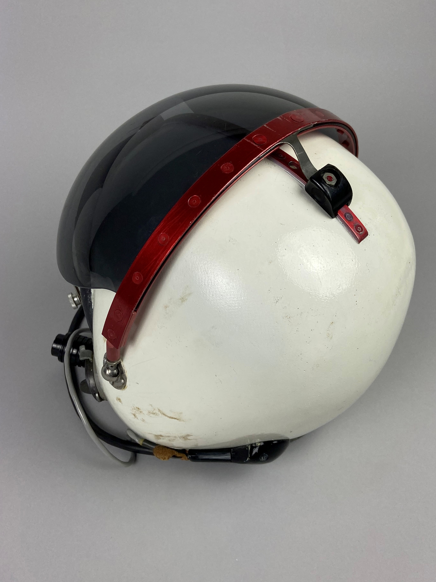 Flyghjälm 111, vit med tonat visir. Separat mikrofon monterad på vänster sida. Brytkoppelanslutning för kommunikation. Utskjutande form vid öronen, insida med förstärkt inlägg av skinn med skumgummifyllning. Hjälmen är försedd med röd metallräls runt hjässan. Skodd nederkant i svart skinn.