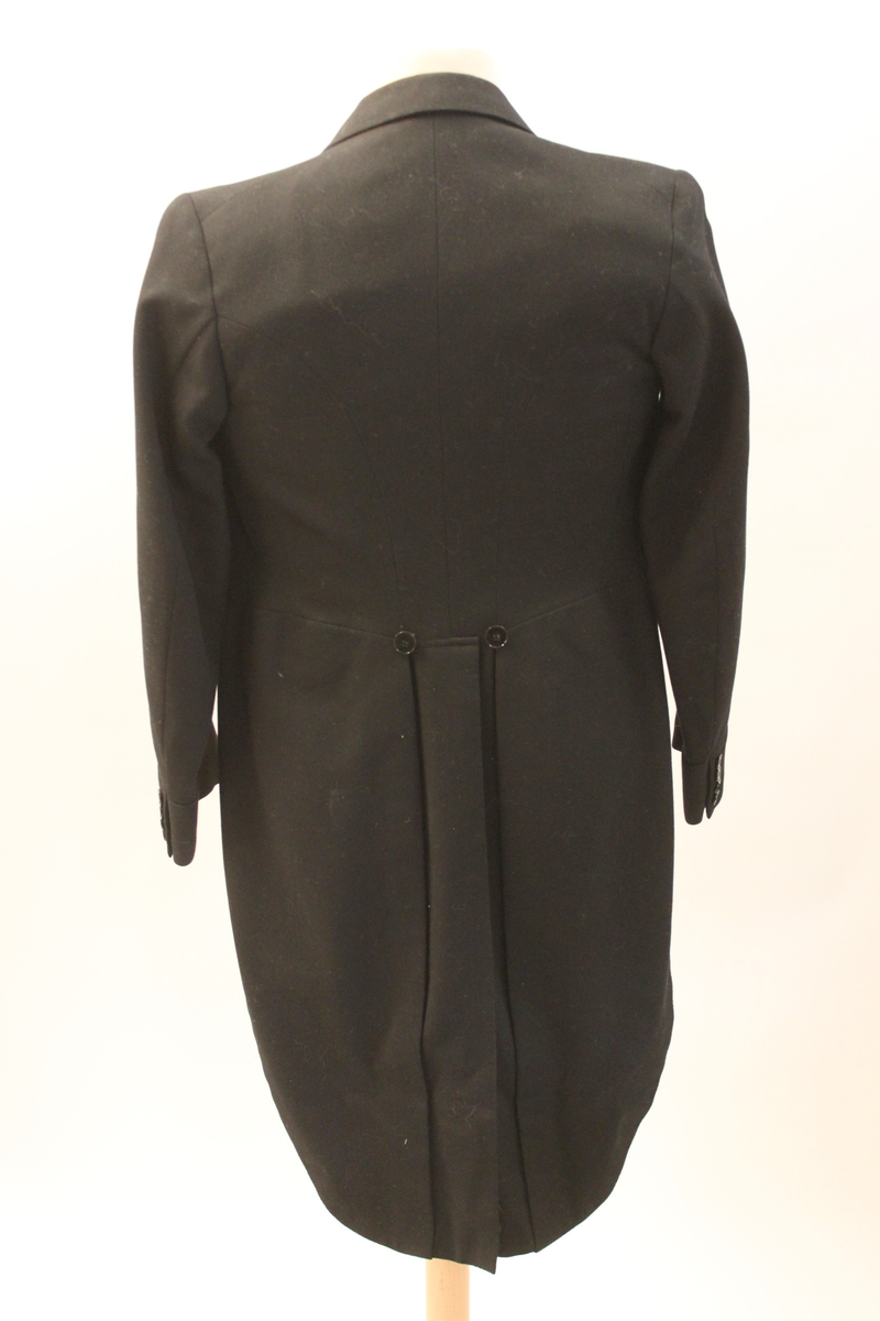 Frackrock, dubbelknäppt med sidenslag. Avskuren i midjan med delat skört bak.