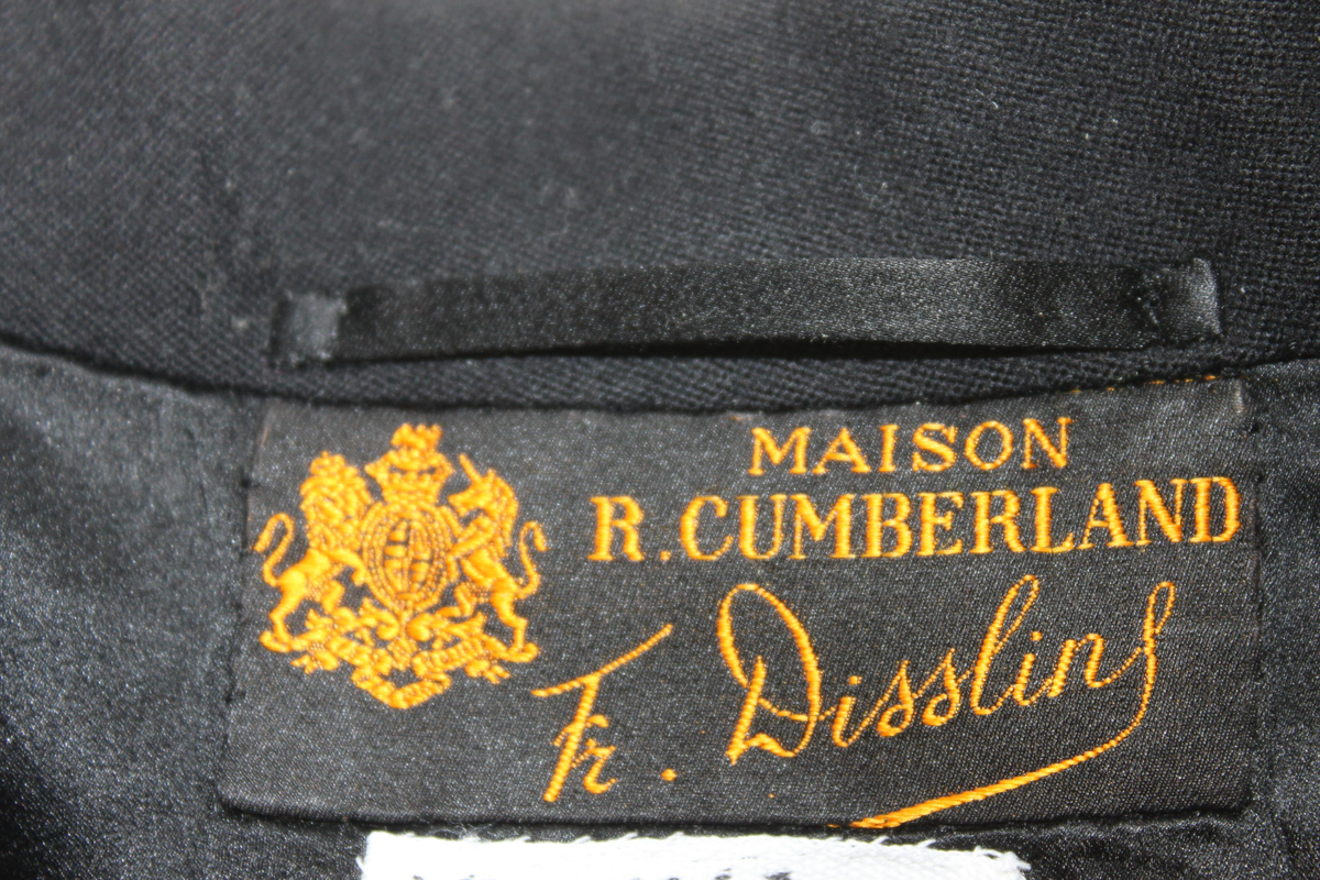 Frackrock, dubbelknäppt med sidenslag. Avskuren i midjan med delat skört bak.