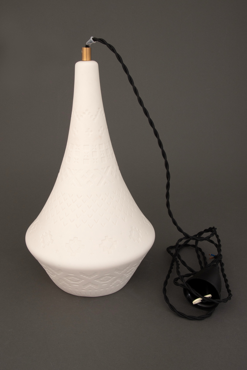 Lampens sandblåste mønster består av "strikkemasker", altså pikselerte punkter (kvadrater, "lus") som skal illudere mønstre fra strikkede klesplagg. En omsirklende rekke av åttebladsroser er det ornamentet som preger mønsteret mest, mens border og punkter er med og skaper assosiasjonene til plagg som gensere og votter. De tekstile referansene gir lampen en lun karakter, noe som forsterkes når lyset i den tennes.