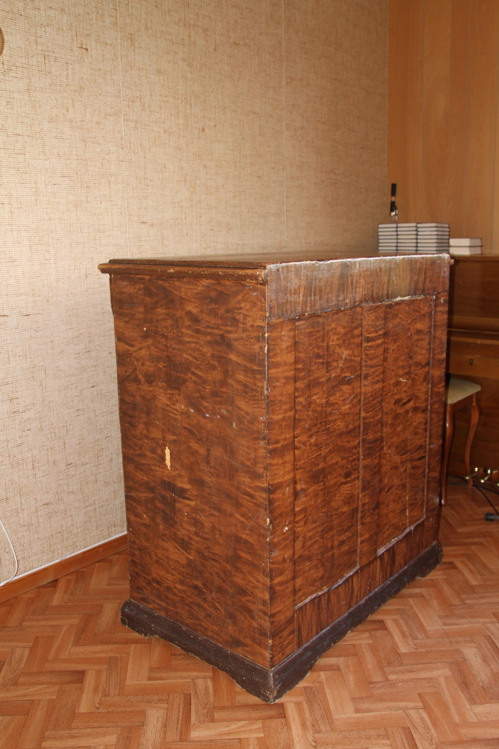 Kateteret er malt og er ådret brunt. Det er høyst slik at læreren må stå ved kateteret. 
Det er skader på list og front.