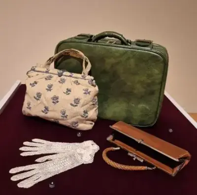 Två handväskor, en portfölj och spetshandskar