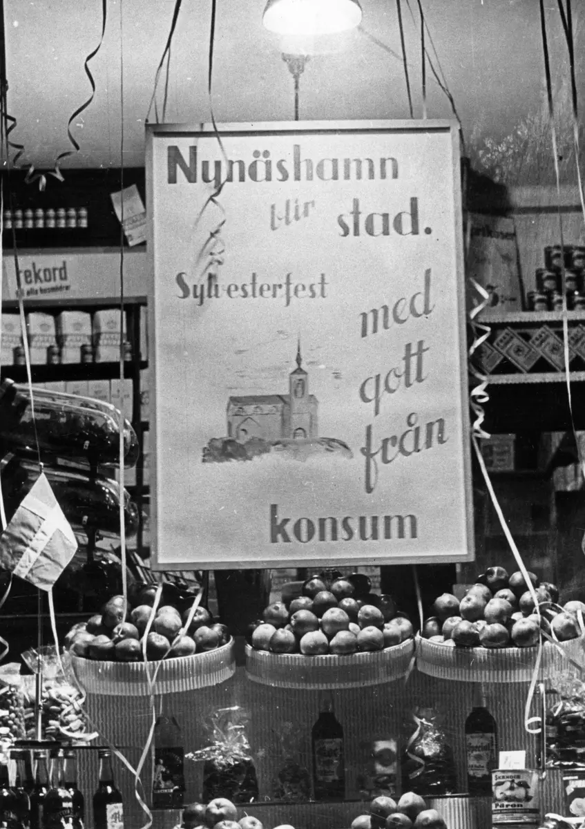 Skyltfönster till Special-Konsum som låg på Nynäsvägen 7, kvarteret Ärlan. Fotografiet visar en nyårsskyltning med anledning av att Nynäshamn blir stad 1 januari 1946.