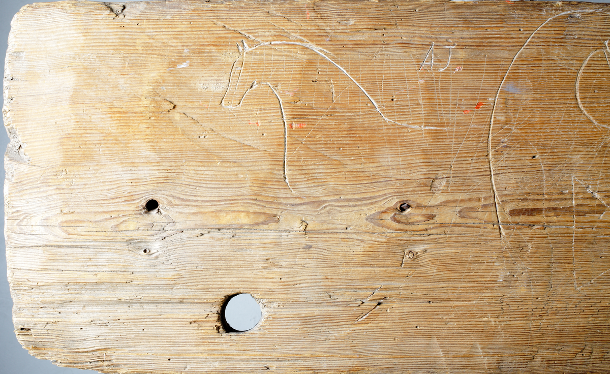 Trollbräda med inristade figurer, huvudsakligen hästbilder.

Inskrivet i huvudkatalog 1935.