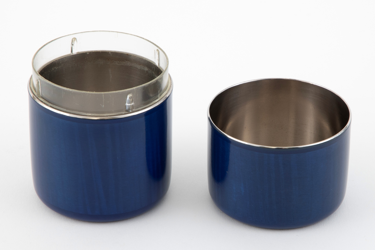 Boks med lokk i rustfritt stål med pålagt emalje. Boksen og lokker er sammen sylinderformet med avrundede kanter. Utsiden er dekket av blå transparent emalje på en strekmønstret bunn. I bunnen er det nedfelt et plastbeger.