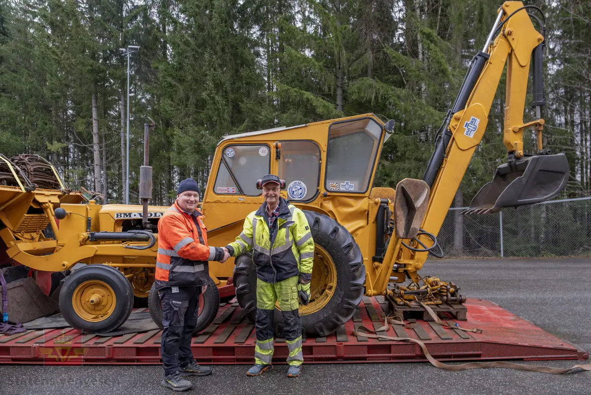 BM-Volvo T-400 traktor med Hymas type 4 graver. Gul, svart og rød traktorgraver lagd i hovedsak av metall, gummi og glass. Merket av produsentene. Dette er en jordbrukstraktor som er påmontert en graver, (gravemaskin), i bakkant. Graveren er hydraulisk drevet og har skuffe og to støtteben. Traktoren er 2-akslet har 6 hjul. To av hjulene er for å kunne bruke traktoren med halvbelter (belter følger med). Motoren er av typen D 913 fra BM, som betyr en tre sylindret firetakts diesel drevet type med slagvolum 2,5 liter. Motoren yter 47 (DIN) Hk. Motoren er bygd med basis fra en Perkins motor. Girkassen har innebygd reduksjons gir som gir åtte gir fremover og to gir bakover. Traktoren har 12 V elektrisk anlegg. Rødt sete merket med BM.
Følgende fulgte med maskinen:
- To skuffer og en hydraulikksentral samt to trekkstenger.
- Fire bilder/tegninger i glass og ramme.
- Regningsblokk.
- Innrammet avisutklipp.