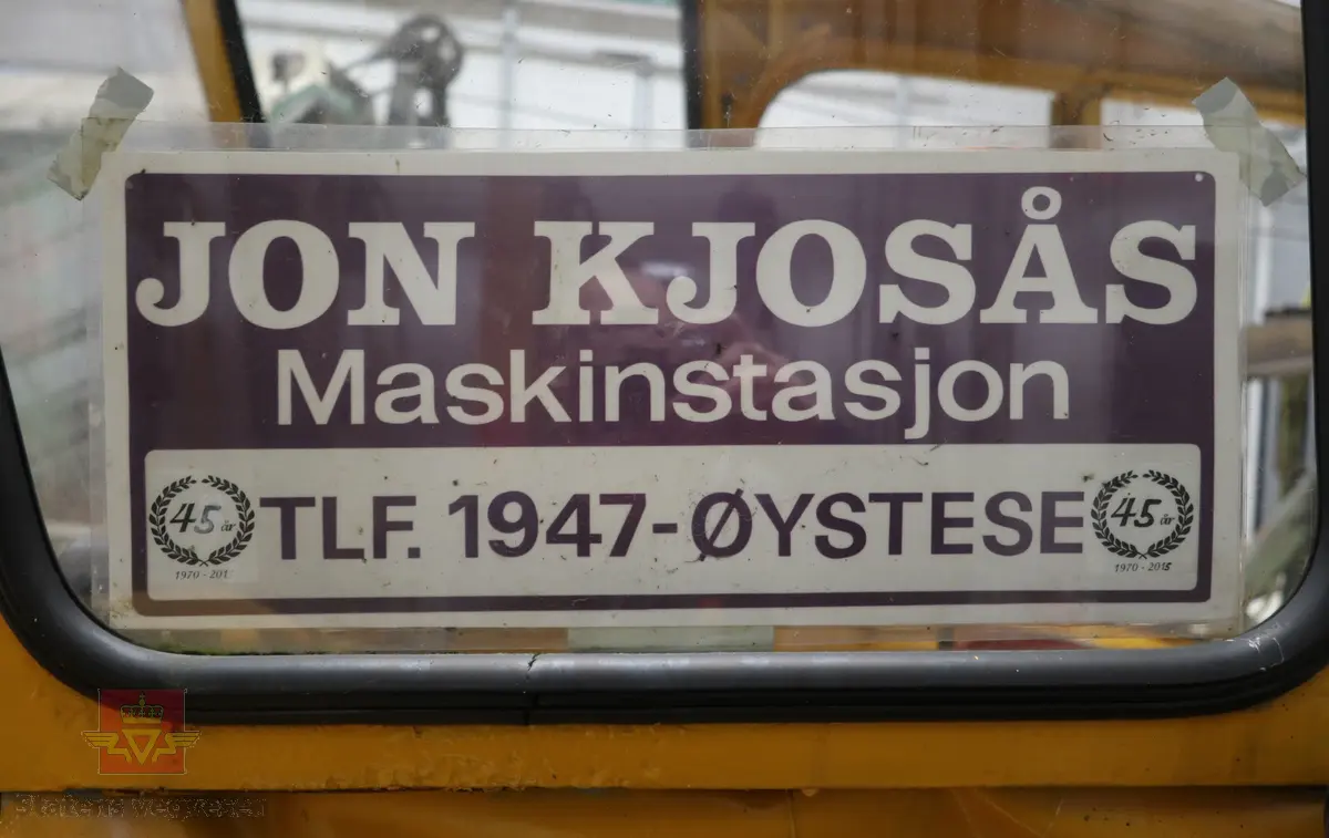 BM-Volvo T-400 traktor med Hymas type 4 graver. Gul, svart og rød traktorgraver lagd i hovedsak av metall, gummi og glass. Merket av produsentene. Dette er en jordbrukstraktor som er påmontert en graver, (gravemaskin), i bakkant. Graveren er hydraulisk drevet og har skuffe og to støtteben. Traktoren er 2-akslet har 6 hjul. To av hjulene er for å kunne bruke traktoren med halvbelter (belter følger med). Motoren er av typen D 913 fra BM, som betyr en tre sylindret firetakts diesel drevet type med slagvolum 2,5 liter. Motoren yter 47 (DIN) Hk. Motoren er bygd med basis fra en Perkins motor. Girkassen har innebygd reduksjons gir som gir åtte gir fremover og to gir bakover. Traktoren har 12 V elektrisk anlegg. Rødt sete merket med BM.
Følgende fulgte med maskinen:
- To skuffer og en hydraulikksentral samt to trekkstenger.
- Fire bilder/tegninger i glass og ramme.
- Regningsblokk.
- Innrammet avisutklipp.