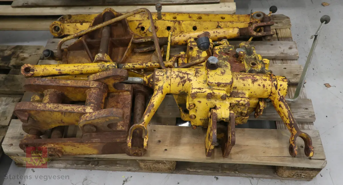 BM-Volvo T-400 traktor med Hymas type 4 graver. Gul, svart og rød traktorgraver lagd i hovedsak av metall, gummi og glass. Merket av produsentene. Dette er en jordbrukstraktor som er påmontert en graver, (gravemaskin), i bakkant. Graveren er hydraulisk drevet og har skuffe og to støtteben. Traktoren er 2-akslet har 6 hjul. To av hjulene er for å kunne bruke traktoren med halvbelter (belter følger med). Motoren er av typen D 913 fra BM, som betyr en tre sylindret firetakts diesel drevet type med slagvolum 2,5 liter. Motoren yter 47 (DIN) Hk. Motoren er bygd med basis fra en Perkins motor. Girkassen har innebygd reduksjons gir som gir åtte gir fremover og to gir bakover. Traktoren har 12 V elektrisk anlegg. Rødt sete merket med BM.
Følgende fulgte med maskinen:
- To skuffer og en hydraulikksentral samt to trekkstenger.
- Fire bilder/tegninger i glass og ramme.
- Regningsblokk.
- Innrammet avisutklipp.