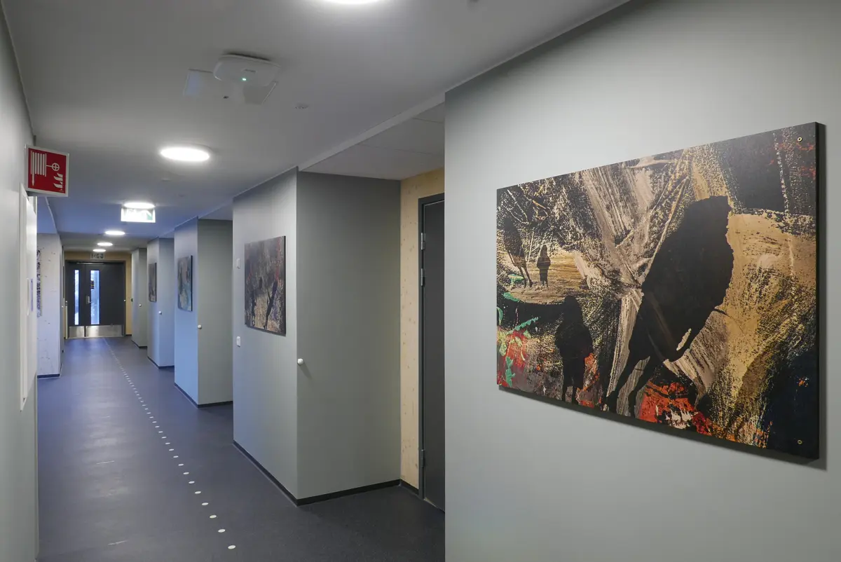 Silhuetter av mennesker mot en bakgrunn med malingsstrøk i forskjellige farger. 