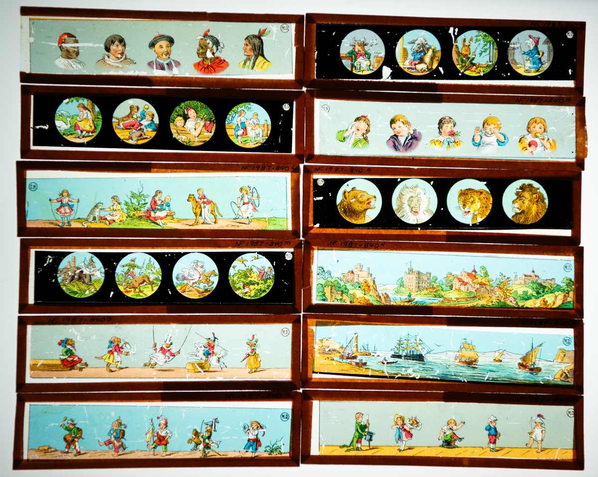 Lysbildefremviser i flere deler med parafinlampe. 12 glassplater med forskjelliger motiver i lysebrune rammer hører til.