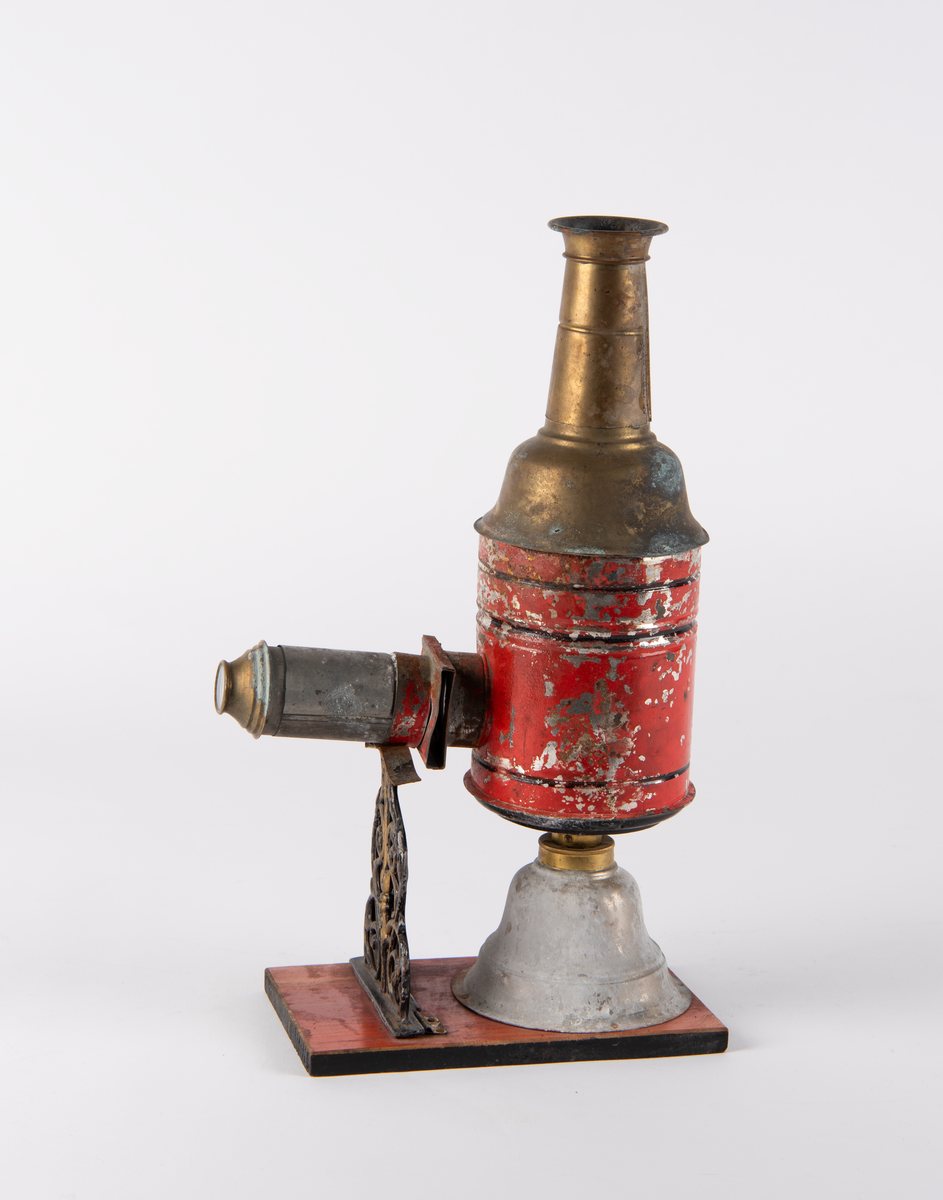 Lysbildefremviser i flere deler med parafinlampe. 12 glassplater med forskjelliger motiver i lysebrune rammer hører til.