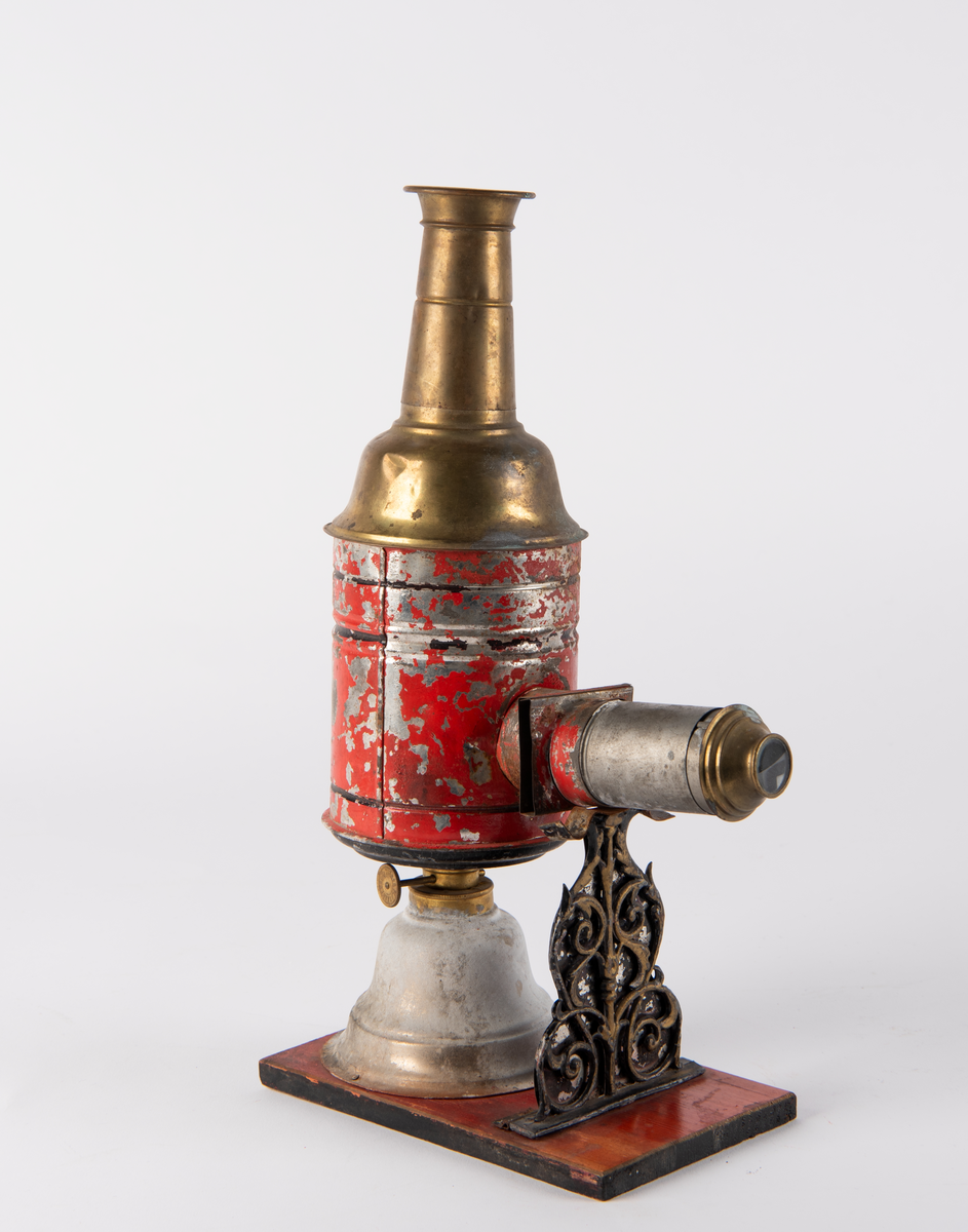 Lysbildefremviser i flere deler med parafinlampe. 12 glassplater med forskjelliger motiver i lysebrune rammer hører til.