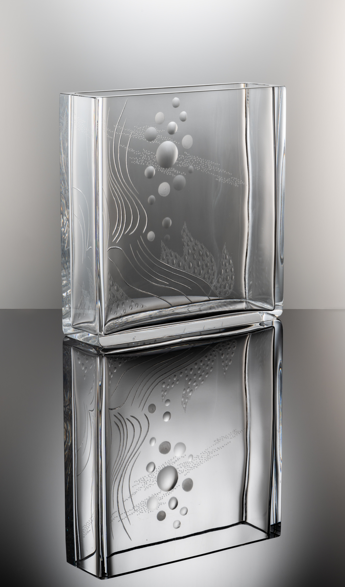 Formgivare: Olle Alberius. Vas, Expo. Rektangulär, tjockväggig vas med graverad abstrakt dekor i form av kulor, linje- och prickmönster.