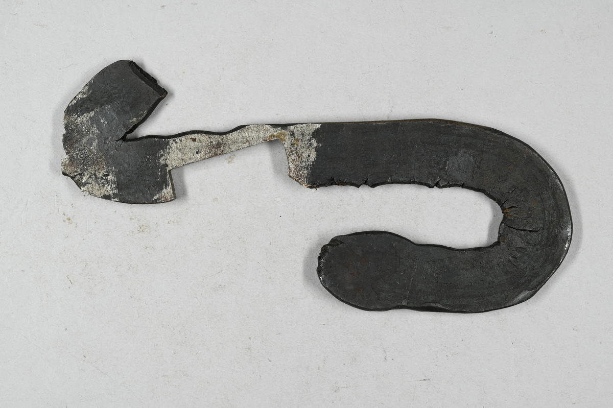 Prov på braknat järn. Tillhörande lapp med notering: "Braknat järn, som vid brunvärme utsmitts av ett vid Uddeholmsverken av en ovan smed tillverkat 2'x 1¤' stångjärn. -Klensmeden anmärkte, att den braknade kanten i brunvärme var 'stelare' eller svårare att böja än den hela. Håller: C 0,18-0,19 %, S 0,0018-0,02 %, R. Dahlström. Cu 0,012 %. C. G. Dahlérus. 1883."