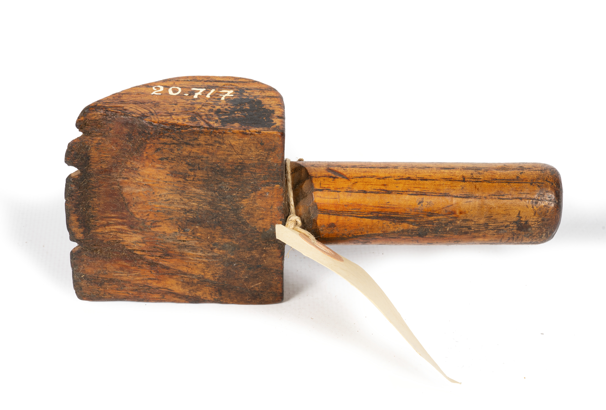 Kvadratisk metallplatta på ett träverktyg men skaft. Används vid hantering av vajer (wire) vid segelmakeri.