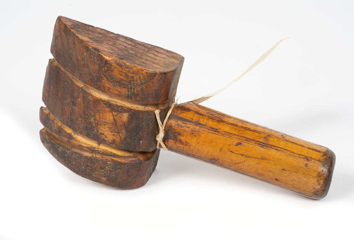 Kvadratisk metallplatta på ett träverktyg men skaft. Används vid hantering av vajer (wire) vid segelmakeri.