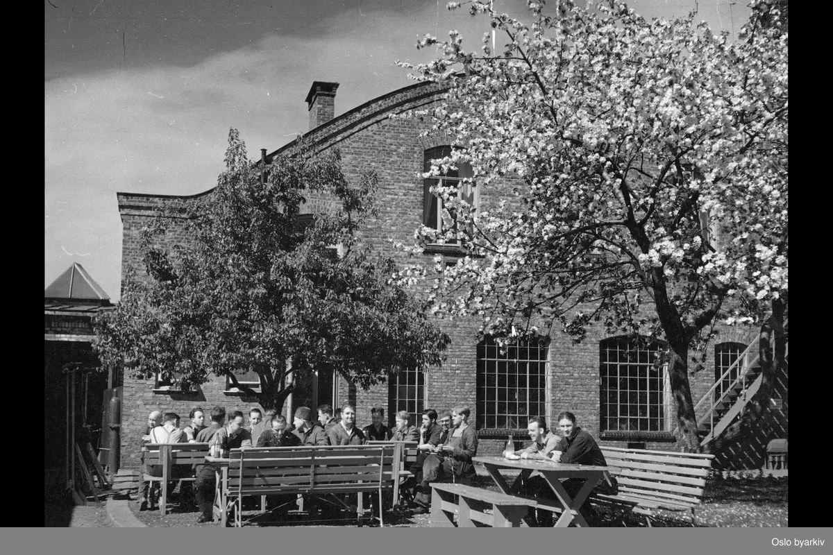 Arbeidere som spiser lunsj utenfor Oslo Sporveiers verksted/anlegg på Sagene.
