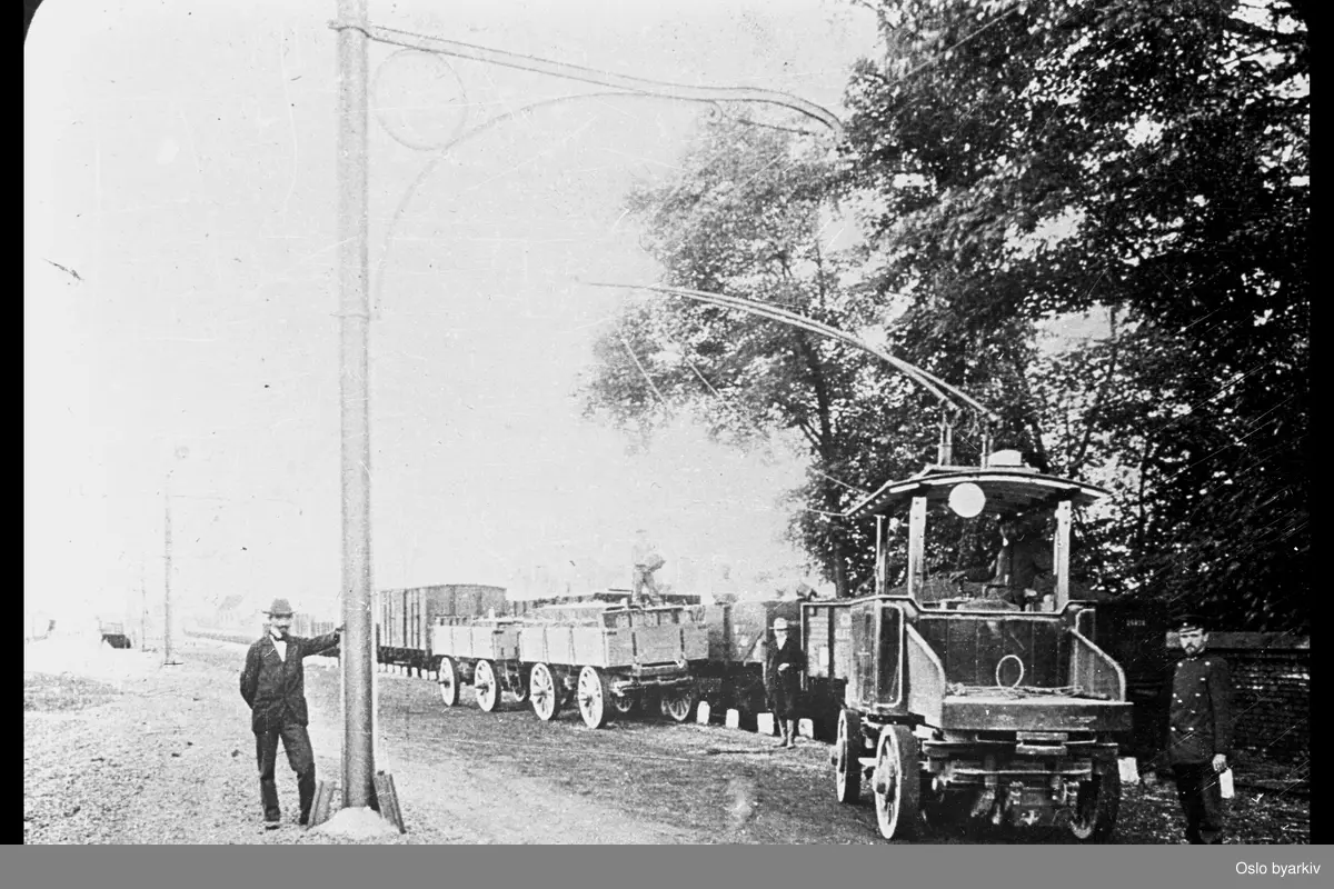 Flere menn som poserer foran lastebiler.