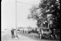 Flere menn som poserer foran lastebiler.