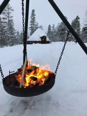 Opptent bålpanne ute på blokkodden. Det er snø og i bakgrunnen ser vi skogen. 