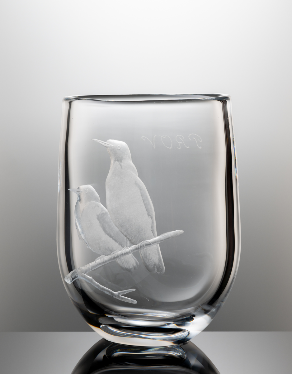 Formgivare: Olle Alberius. Vas med oval plattad form och indragen rundad bas. Graverad med två fåglar sittandes på en gren.
Gravör, (troligen) Ljupco Kocovski, verksam vid bruket 1978-80.