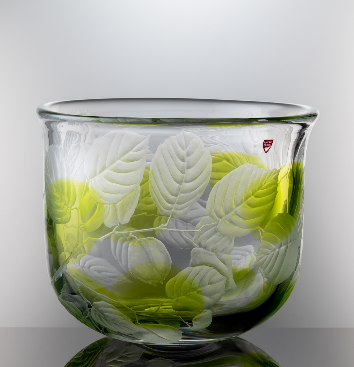 "Sommardröm" Formgivare: Olle Alberius. Skål, Expo. Klockformad med insvängd rundad bas. Graverad dekor i form av kvistar med löv och åtta inlagda ovaler i ljusgrön färg.