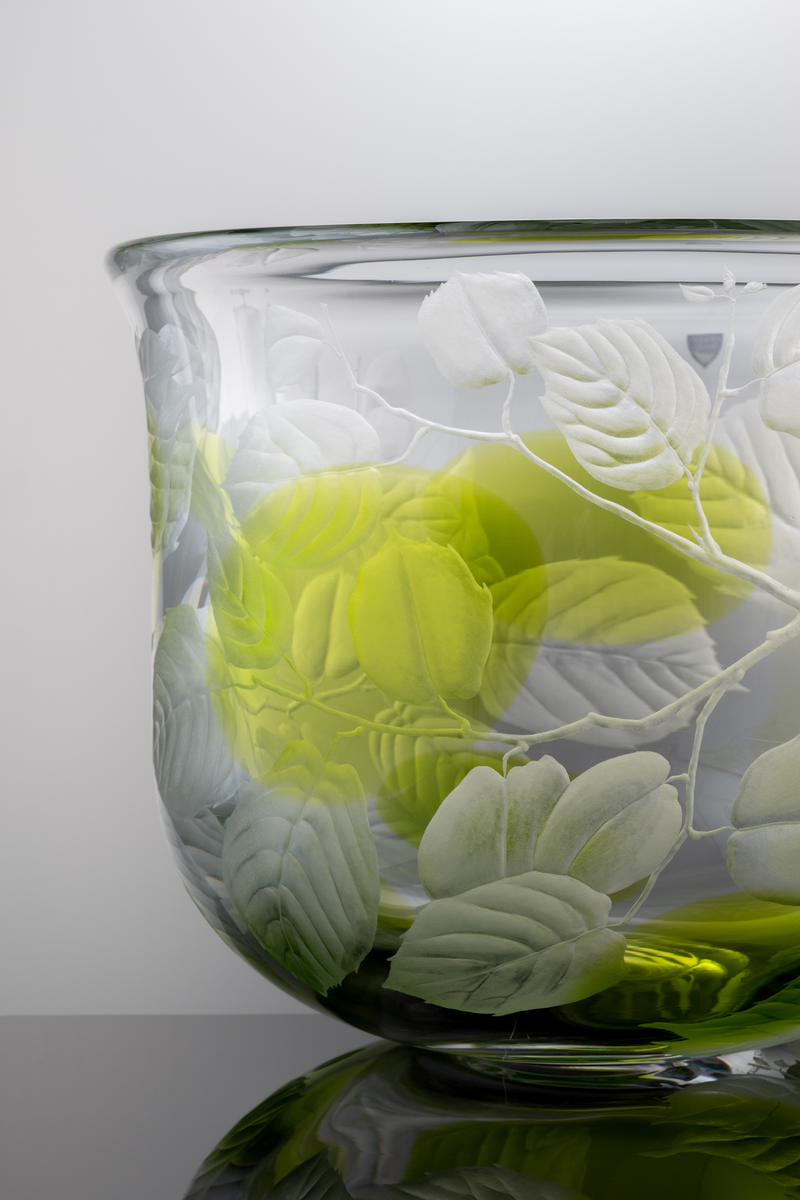 "Sommardröm" Formgivare: Olle Alberius. Skål, Expo. Klockformad med insvängd rundad bas. Graverad dekor i form av kvistar med löv och åtta inlagda ovaler i ljusgrön färg.