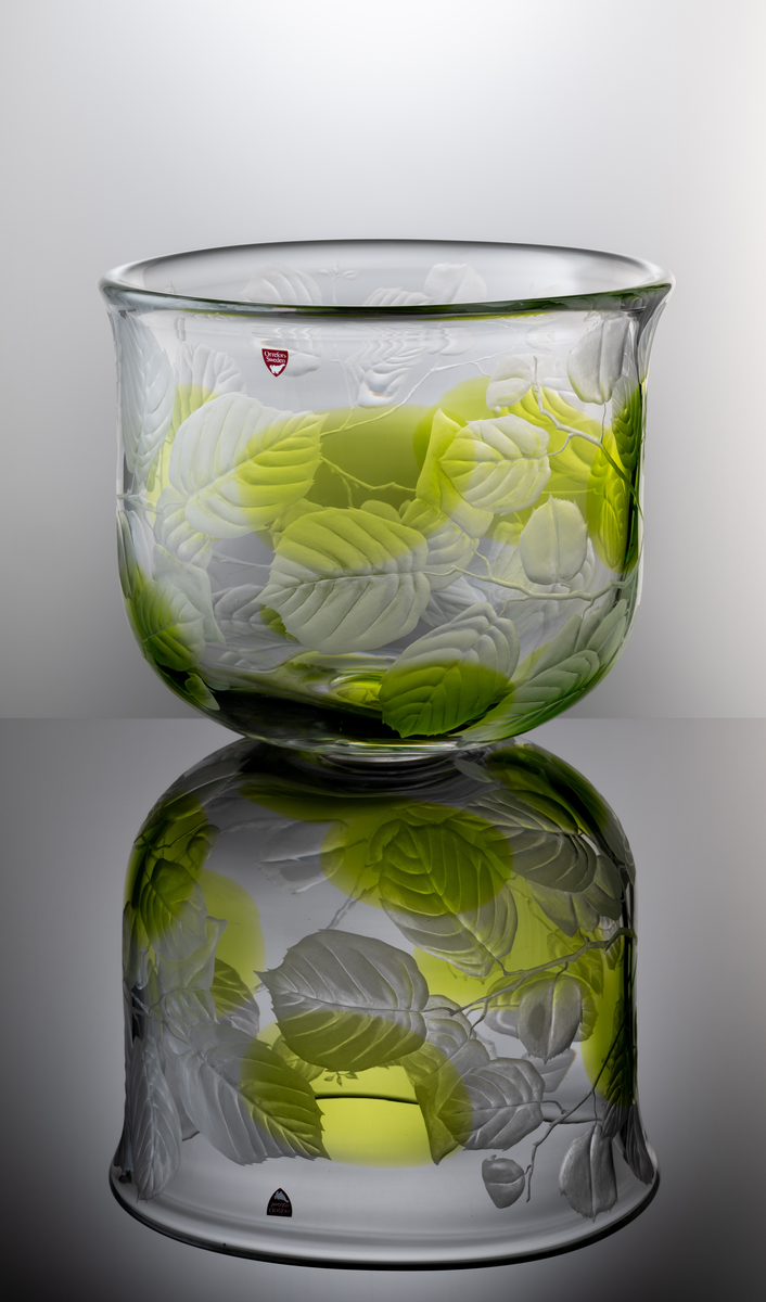 "Sommardröm" Formgivare: Olle Alberius. Skål, Expo. Klockformad med insvängd rundad bas. Graverad dekor i form av kvistar med löv och åtta inlagda ovaler i ljusgrön färg.