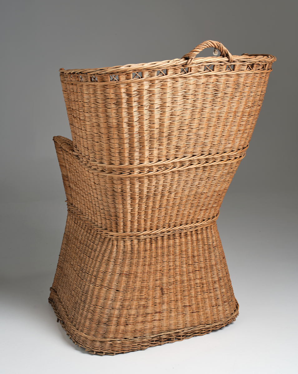 Nattstol fra Hans Nissengården laget av flettet tremateriale. Stolen har en pute av samme flettet materiale og et hull i setet for bruk som do. 