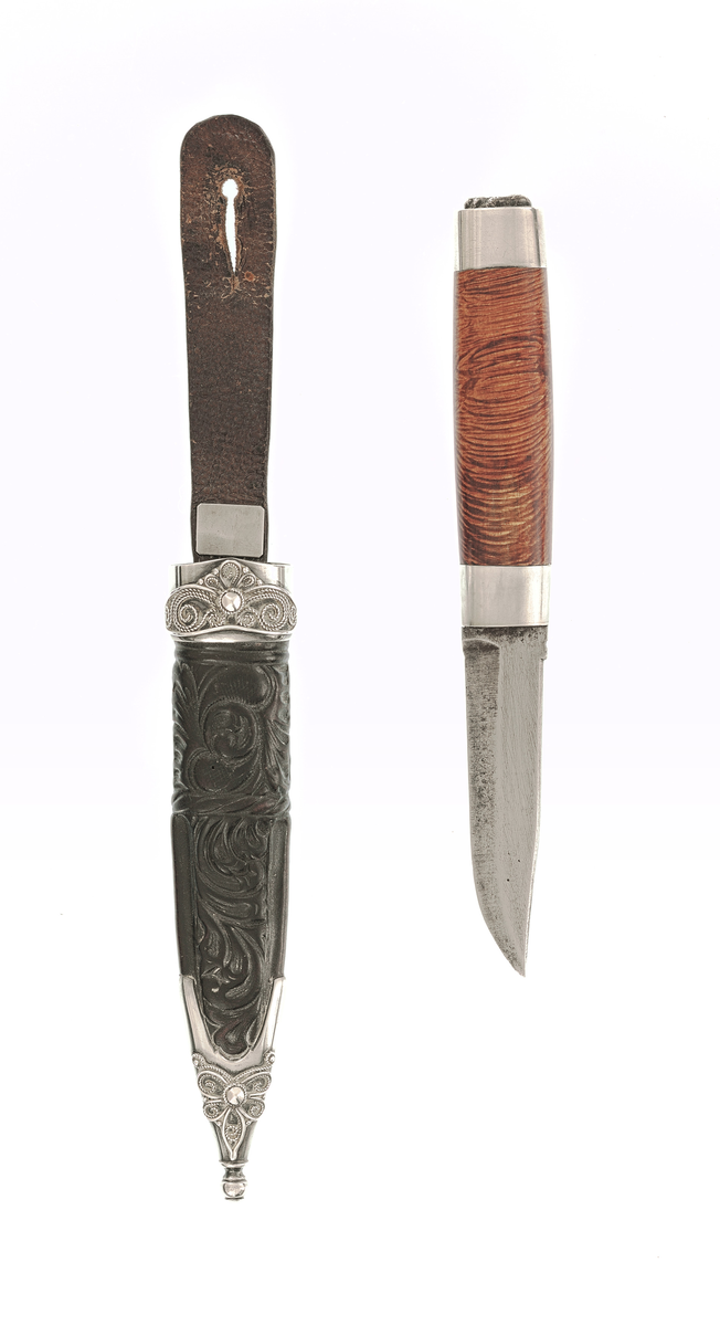 Staskniv frå knivmakar Hans Sjåberg.

Kniven har skaft av treverk med enkle sylvholkar. Glibb forma som liggande bikkje.

Slira er av lêr og har pauta rankemønster. Holk og doppsko i sylv med filigranarbeid.
