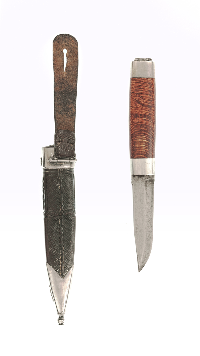 Staskniv frå knivmakar Hans Sjåberg.

Kniven har skaft av treverk med enkle sylvholkar. Glibb forma som liggande bikkje.

Slira er av lêr og har pauta rankemønster. Holk og doppsko i sylv med filigranarbeid.
