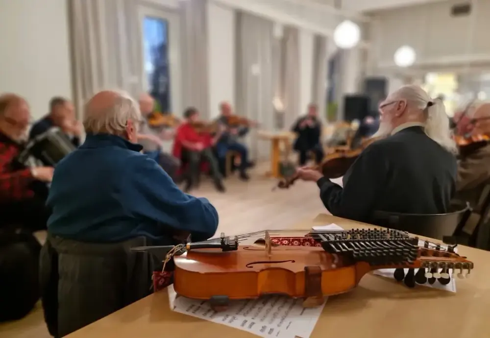 Personer som spelar instrument med ett instrument i förgrunden.