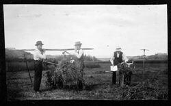 Fire menn på en åker driver med innhøsting.