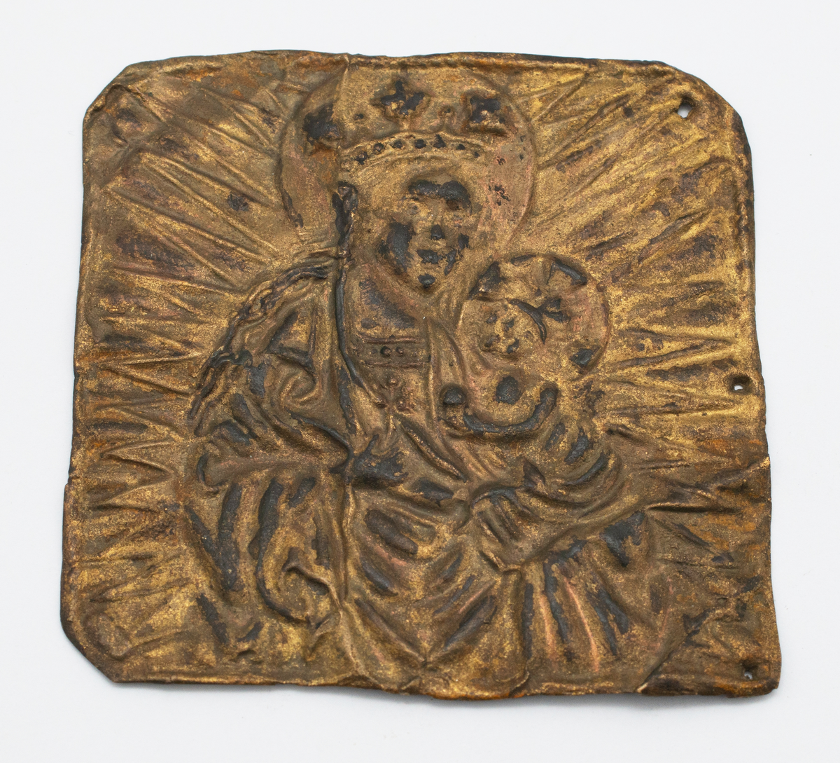 Förgylld kopparplåt med pressad bild av madonnan och barnet omgiven av en strålgloria. Tre hål i plåtens högra sida.