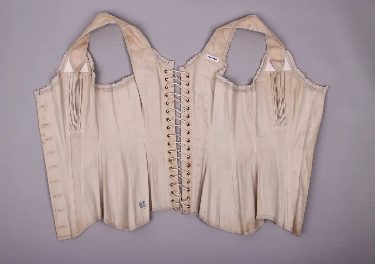 Reformliv, "sanitetslif". Stämplad på två ställen: Rött kors i ring med texten Sanitetslif. Knappar av pressat vitt glas.