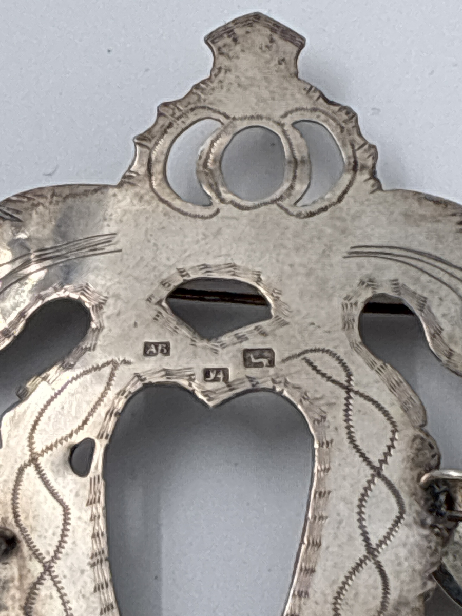 Hjärtformad bröstsölja med nio skålformade hängen.

Stadsstämpel: Hjorten= Alingsås
Årsstämpel: Y4= 1853
Mästarstämpel: AB= Anders Bäck