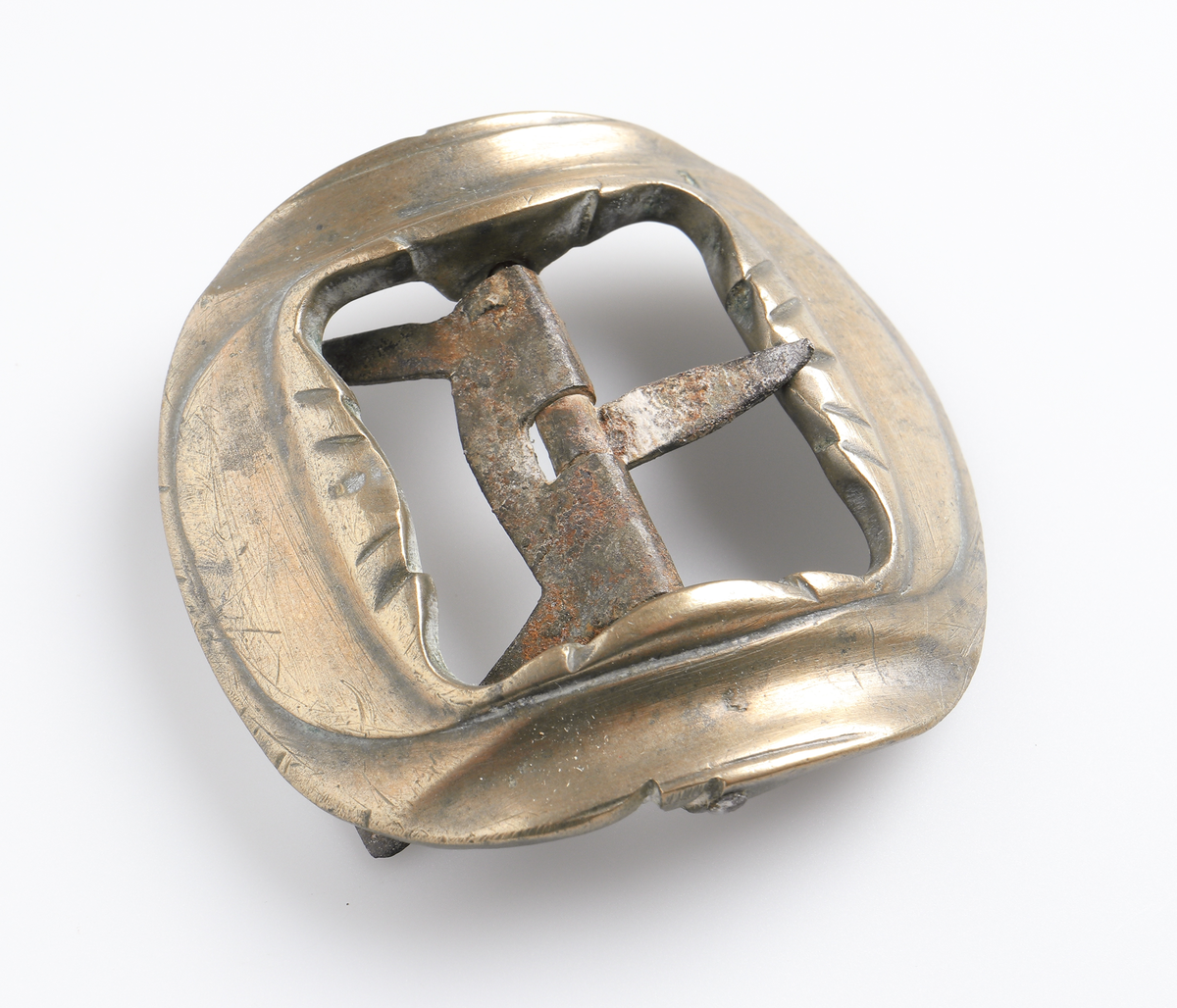 Knäspänne av gjuten gulmetall, med nål och fäste av järn. Avrundad fyrkantig form, något välvd.

Inskrivet i huvudbok 1886.