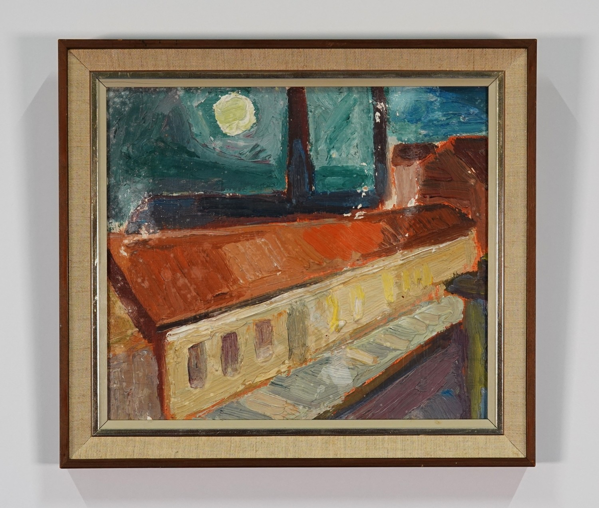 Fabrik i månljus. I förgrunden ett gult långt hus, i bakgrunden ett mörkare hus med två skorstenar.