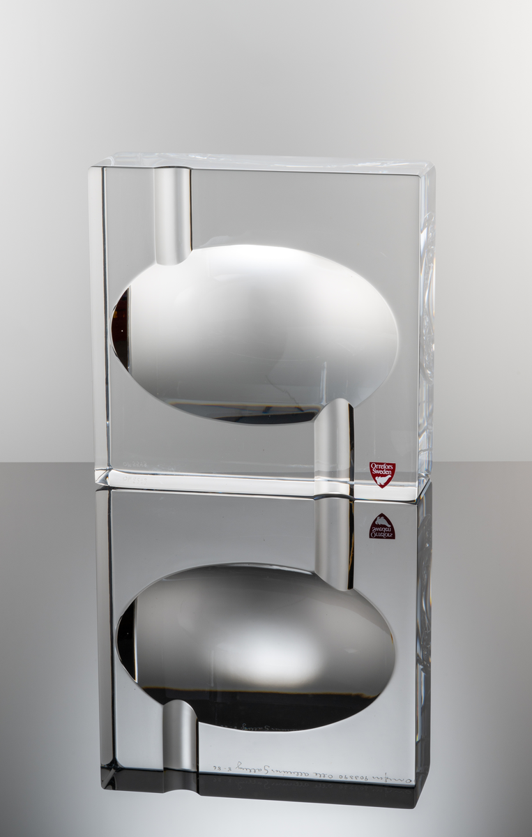 Formgivare: Olle Alberius. Askfat, kvadratiskt glasblock med rund nedsänkning och två slipade urtag för cigaretter