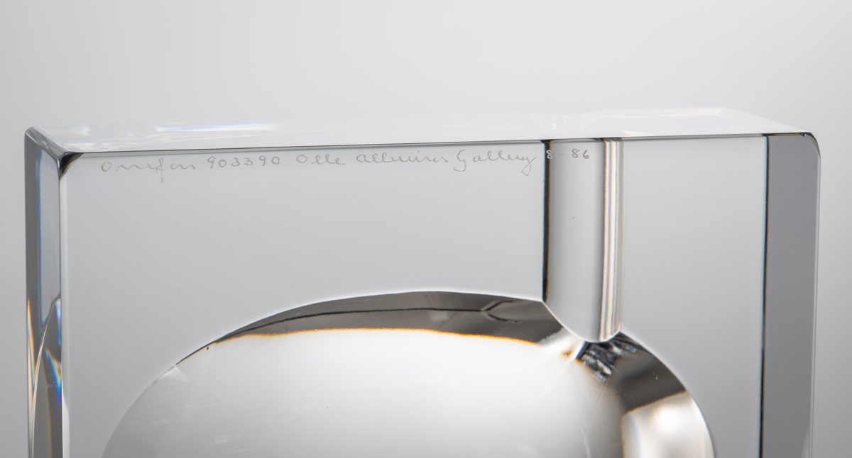 Formgivare: Olle Alberius. Askfat, kvadratiskt glasblock med rund nedsänkning och två slipade urtag för cigaretter