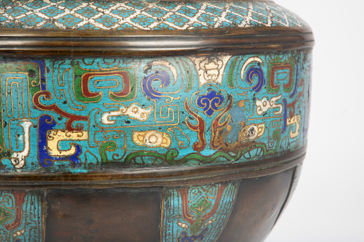 Kar i kobber, eventuelt en kobberlegering. Karet har en markert fotring som går over i en korpus med størst diameter omtrent midt på, før den trekker seg noe inn mot åpningen. Øverst avsluttes karet med en profilert munningskant. Rikt dekorert med et emaljert, polykromt mønster i cloisonné. På korpus et sammenhengende belte fylt med stiliserte, symmetriske ornamenter utført i turkist, grønt, hvitt, rødt og blått. Over dette et smalere belte med et repeterende geometrisk mønster i turkist og hvitt. Nederst på korpus felter med stiliserte, symmetriske ornamenter utført i turkist, grønt, hvitt, rødt og blått.